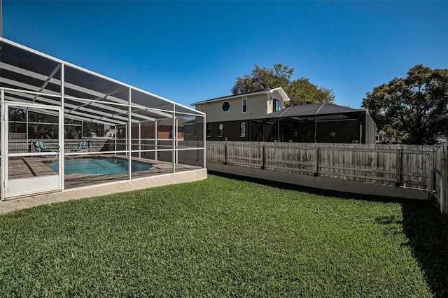 view of yard with glass enclosure, a fenced backyard, and a fenced in pool