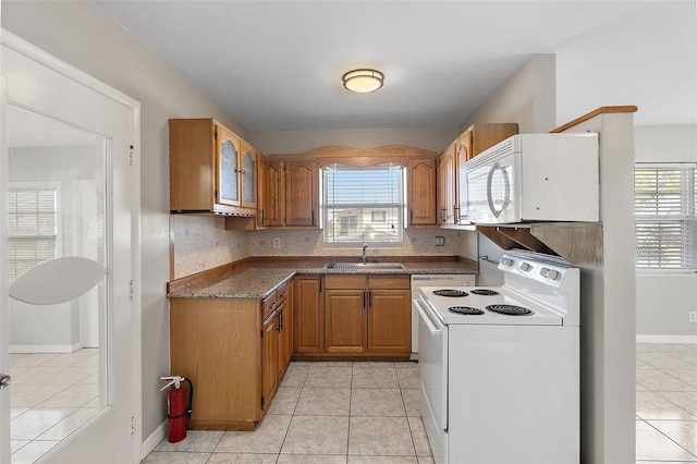 kitchen with white appliances, a healthy amount of sunlight, a sink, and brown cabinets