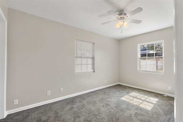 carpeted empty room featuring a ceiling fan and baseboards