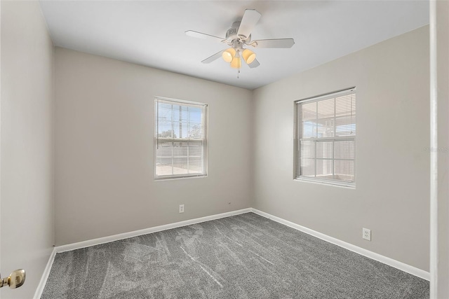 carpeted spare room featuring ceiling fan and baseboards