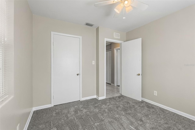 unfurnished bedroom featuring a ceiling fan, carpet, visible vents, and baseboards