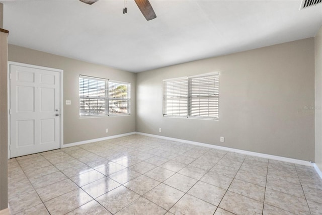 unfurnished room featuring a ceiling fan, visible vents, baseboards, and light tile patterned floors