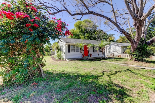 ranch-style house with a front yard and fence