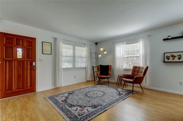 foyer with a wealth of natural light, baseboards, and wood finished floors