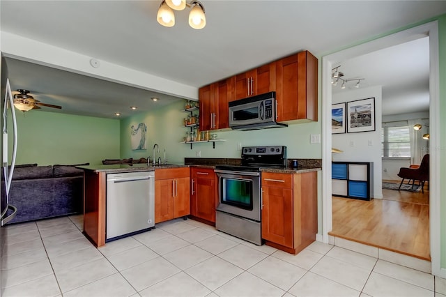 kitchen with stainless steel appliances, open floor plan, a peninsula, and ceiling fan