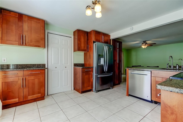 kitchen with ceiling fan, dark stone counters, appliances with stainless steel finishes, and a sink