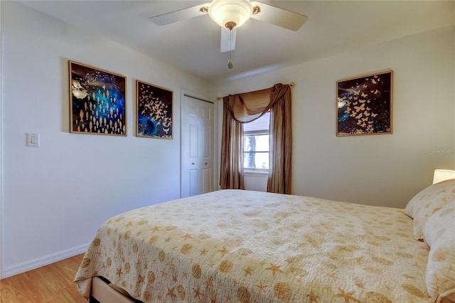 bedroom featuring a closet, ceiling fan, light wood-type flooring, and baseboards