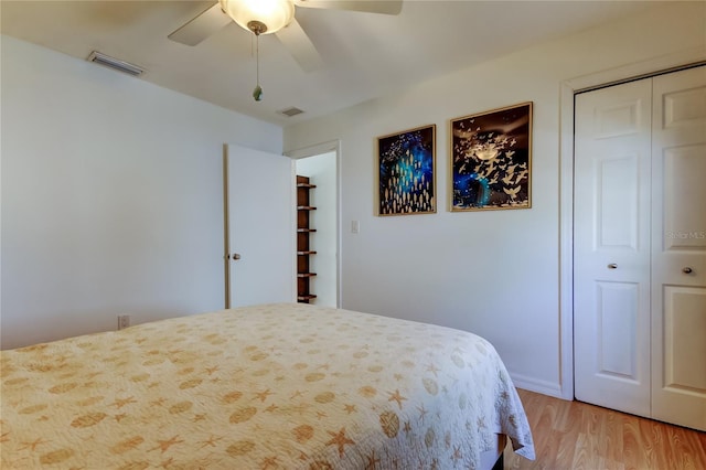 bedroom featuring light wood finished floors, visible vents, ceiling fan, and a closet