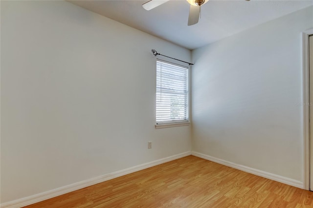 unfurnished room featuring a ceiling fan, light wood-type flooring, and baseboards