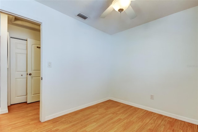 spare room with light wood-style flooring, baseboards, visible vents, and ceiling fan