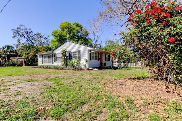 back of house featuring a yard and fence