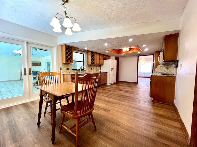 1811 Tawnee Pl, Brandon, FL 33510 - dining room featuring a textured ceiling, wood finished floors, a notable chandelier, and baseboards