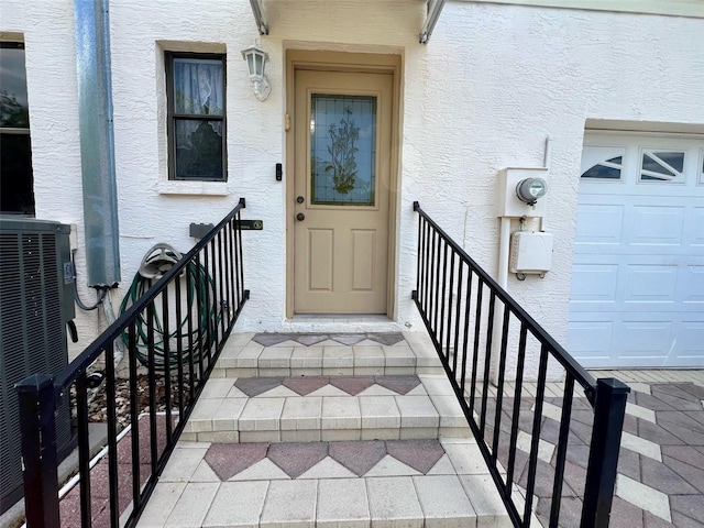 1811 Tawnee Pl, Brandon, FL 33510 - property entrance with stucco siding, central air condition unit, and a garage
