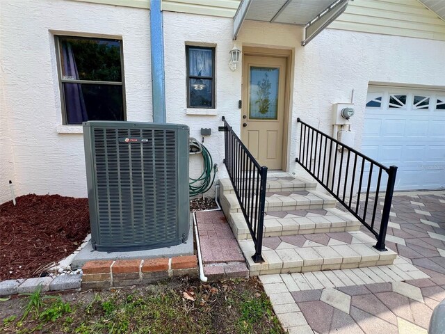 1811 Tawnee Pl, Brandon, FL 33510 - property entrance with cooling unit, a garage, and stucco siding