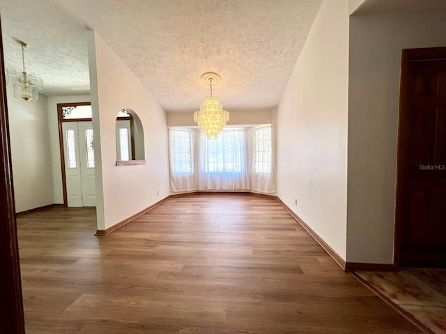 1811 Tawnee Pl, Brandon, FL 33510 - unfurnished dining area with a textured ceiling, wood finished floors, a notable chandelier, and baseboards