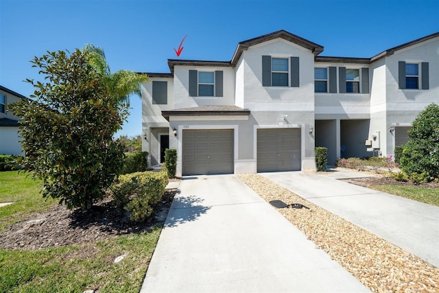 view of front of property with driveway, an attached garage, and stucco siding