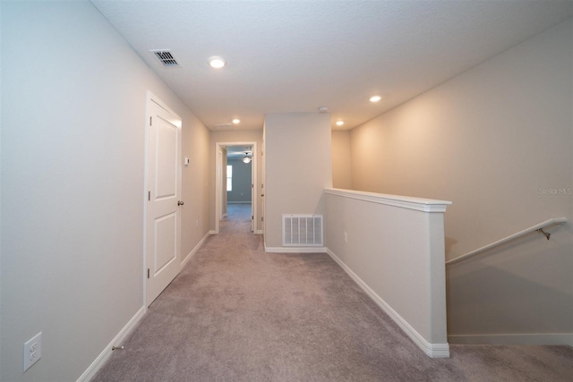 hallway with recessed lighting, baseboards, visible vents, and an upstairs landing