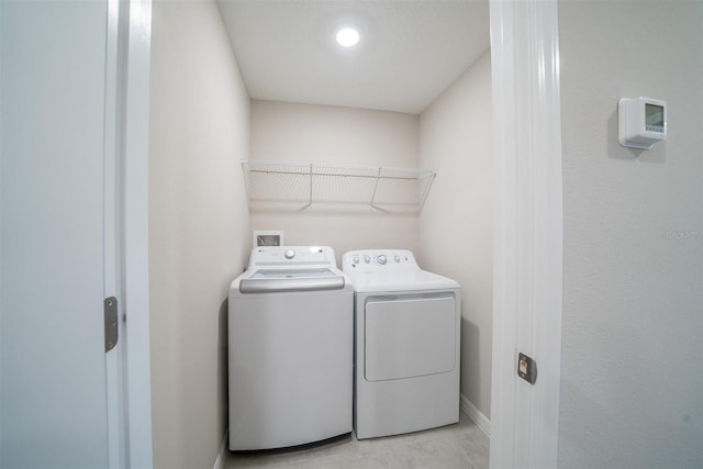 laundry area with laundry area, baseboards, and separate washer and dryer