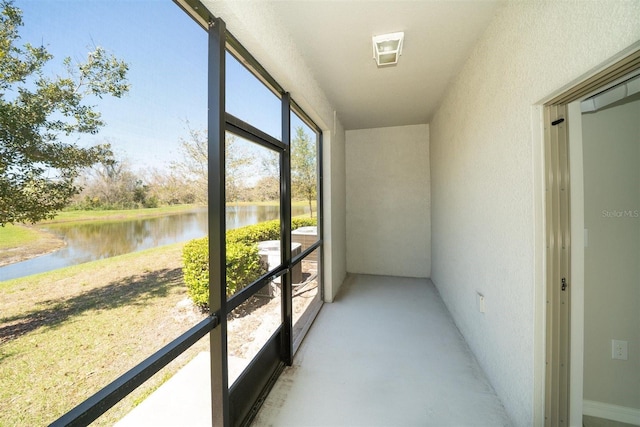 unfurnished sunroom featuring a water view