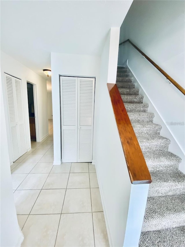 stairs with baseboards and tile patterned floors