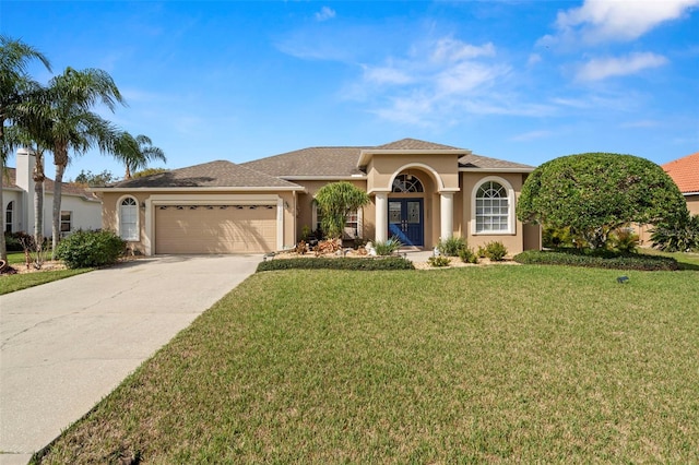 mediterranean / spanish-style home featuring an attached garage, a front lawn, concrete driveway, and stucco siding