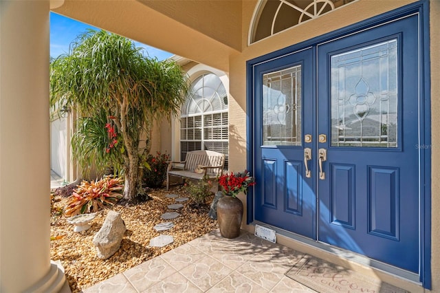 property entrance featuring stucco siding and french doors