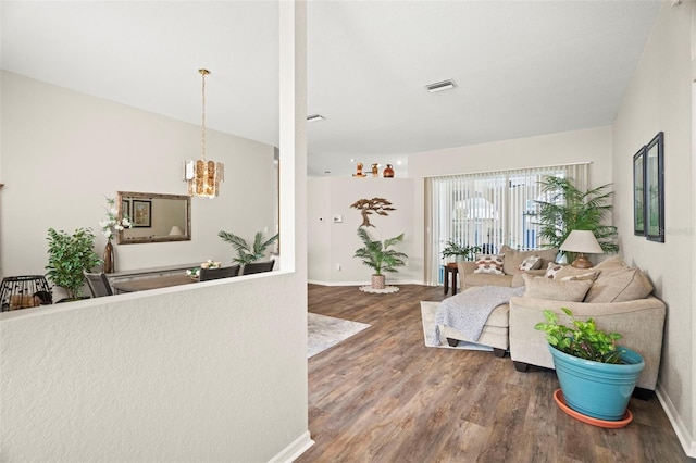 living room with a notable chandelier, baseboards, and wood finished floors