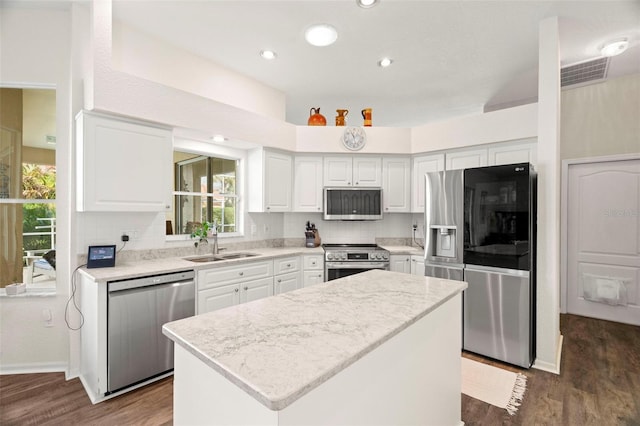 kitchen featuring visible vents, white cabinets, appliances with stainless steel finishes, dark wood-style flooring, and a sink