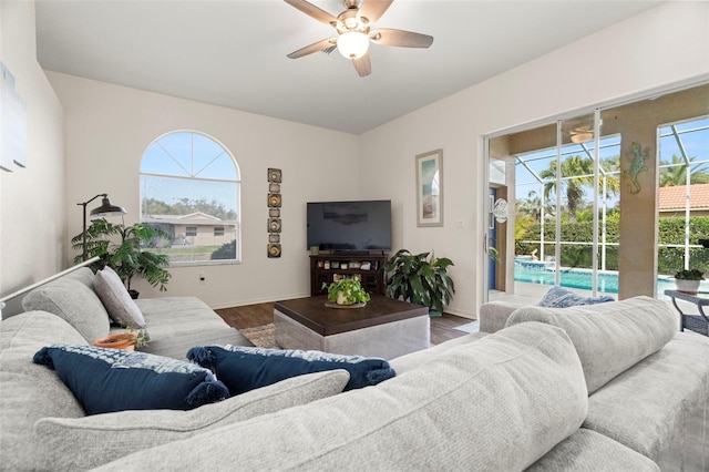 living area featuring a healthy amount of sunlight, ceiling fan, baseboards, and wood finished floors