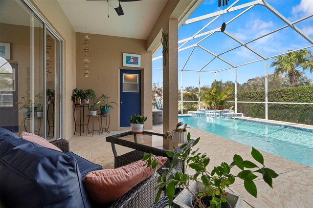 outdoor pool featuring glass enclosure, a patio area, and a ceiling fan