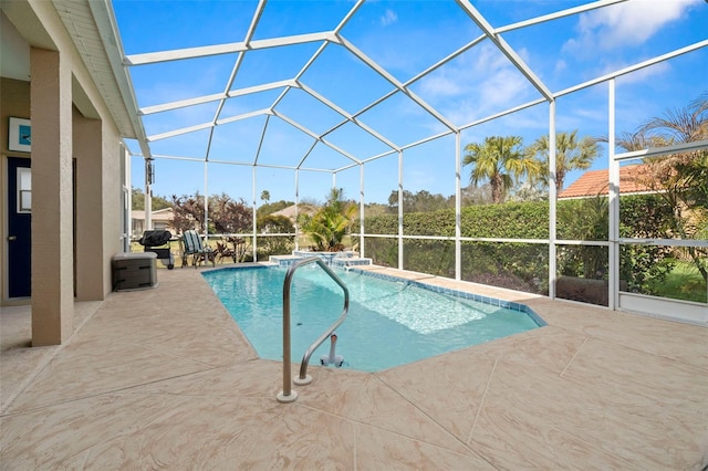 view of swimming pool featuring a patio area, a pool with connected hot tub, and glass enclosure