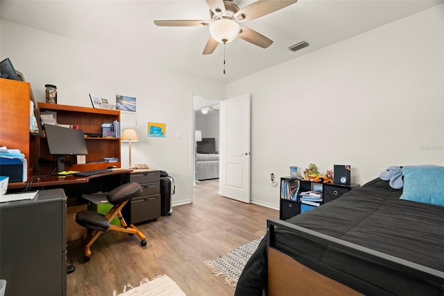 bedroom featuring a ceiling fan, baseboards, visible vents, and wood finished floors