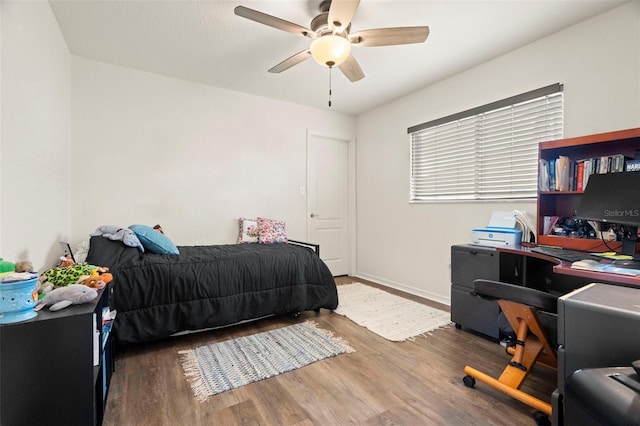 bedroom featuring a ceiling fan, baseboards, and wood finished floors