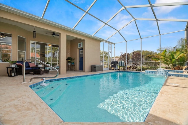 pool featuring glass enclosure, a ceiling fan, and a patio