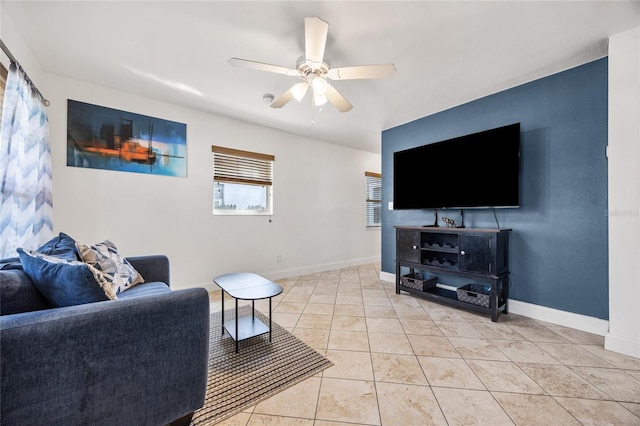 living area featuring ceiling fan, baseboards, and light tile patterned floors