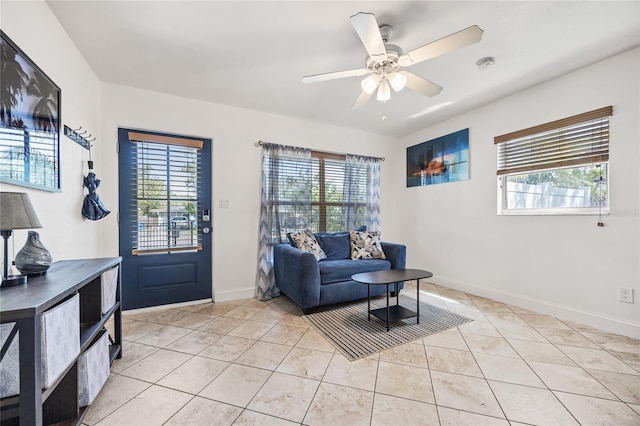 interior space with light tile patterned floors, plenty of natural light, a ceiling fan, and baseboards