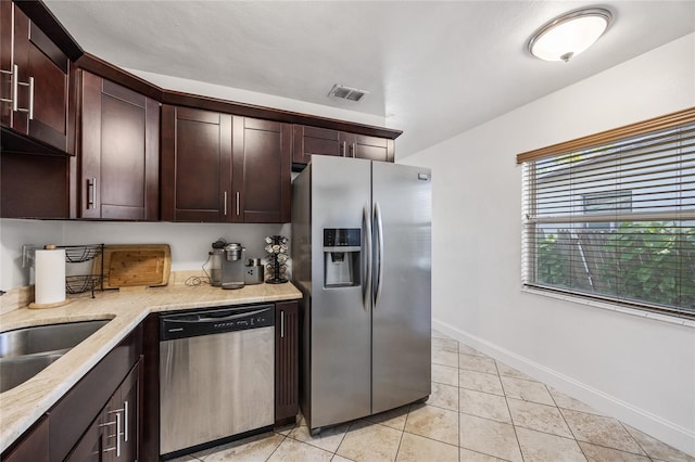 kitchen featuring stainless steel appliances, visible vents, light tile patterned flooring, dark brown cabinetry, and baseboards