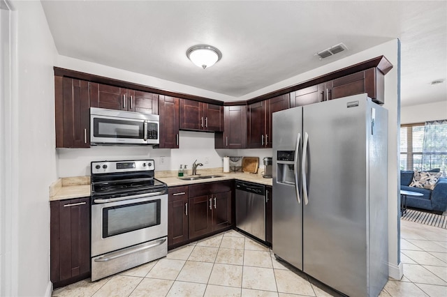 kitchen featuring light tile patterned flooring, a sink, visible vents, light countertops, and appliances with stainless steel finishes