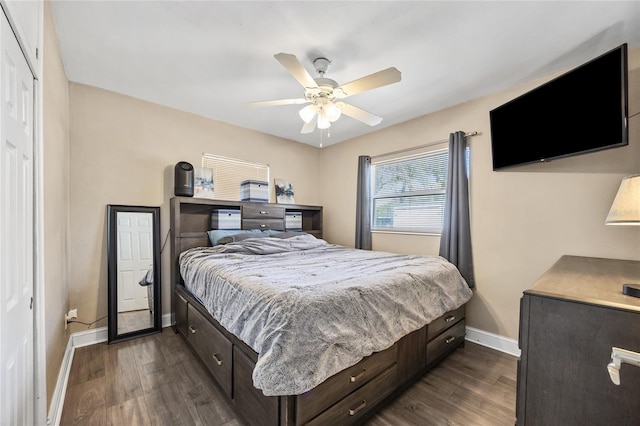 bedroom featuring dark wood-style floors, a ceiling fan, and baseboards