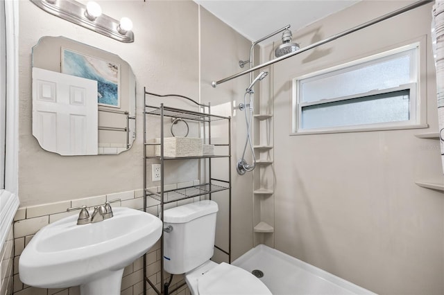 bathroom with a walk in shower, a sink, and toilet