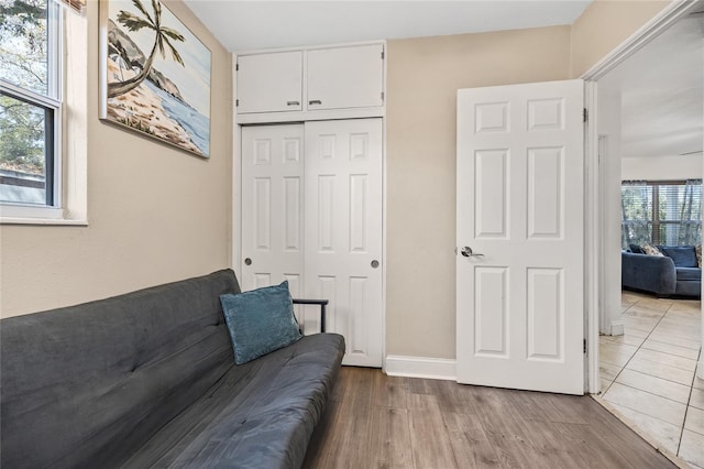 living area with baseboards and wood finished floors