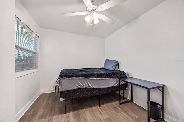 bedroom featuring wood finished floors, a ceiling fan, and baseboards