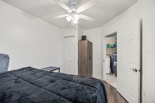 bedroom with washer / clothes dryer, a closet, wood finished floors, and a ceiling fan