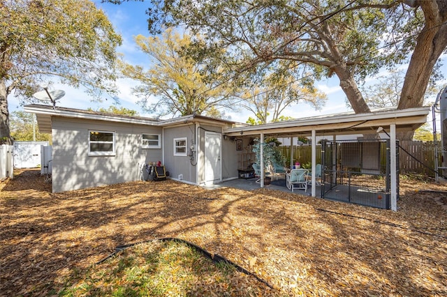 rear view of house featuring fence and a patio