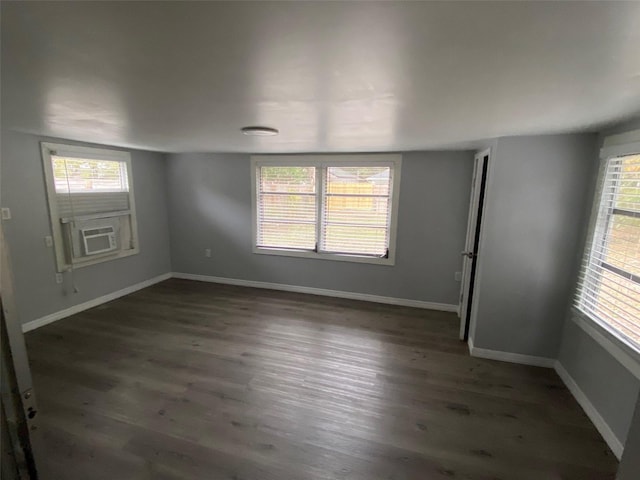 empty room with a healthy amount of sunlight, baseboards, and wood finished floors