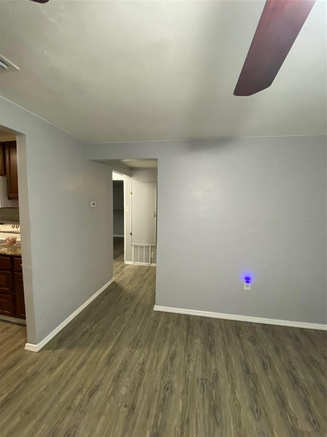 unfurnished room with visible vents, baseboards, and dark wood-type flooring