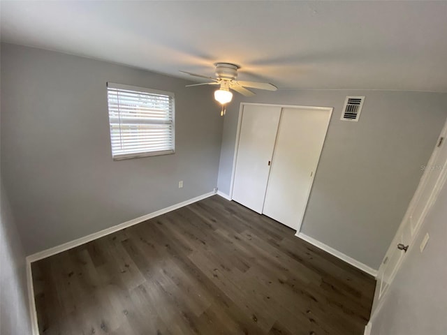 unfurnished bedroom with visible vents, baseboards, a ceiling fan, dark wood finished floors, and a closet