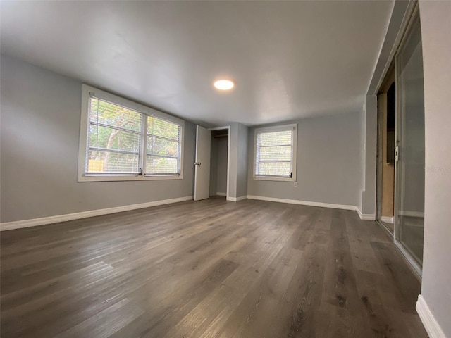 unfurnished bedroom with dark wood finished floors and baseboards