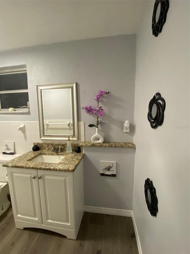 bathroom with vanity, baseboards, and wood finished floors