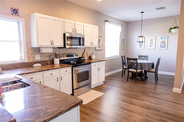 kitchen with visible vents, appliances with stainless steel finishes, white cabinets, and backsplash